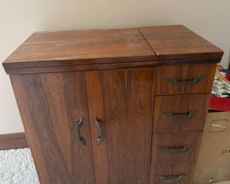 vintage sewing cabinet with drawers and a hinged top