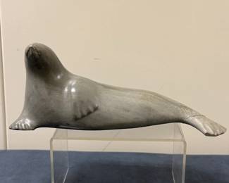 Inuit Figurine (Canadian) - Seal Laying Down | Stone carving of a seal laying down with its flipper on its belly. 
Soapstone carving
Signed by artist (bottom): Numbered and contains the "igloo tag trademark" of authenticity: "Canada Inuit Art"
Titled by artist: N/A
Numbered by artist: N/A