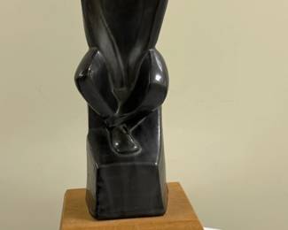 Mohamed Hussein Hagras (Egyptian, 1924-2004) Sculpture - "Man Seated" | Black marble or other material carved sculpture of a man seated, looking down, with his hands in his lap. 
Sculpture
Wooden base
Signed by artist (bottom): "Mohamed Hagrass"
Titled by artist: N/A
Numbered by artist (bottom): "1 of 3 originals" - h. 12.5 x w. 6 x d. 5 in