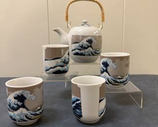 (5pc) After Katsushika Hokusai (Japanese, 1760-1849) Tea Set - "The Great Wave off Kanagawa" | Tea set adorned with Katsushika Hokusai’s iconic "The Great Wave off Kanagawa" (circa 1830), the most famous print from his "Thirty-Six Views of Mount Fuji" series, celebrated for its lasting influence on artists and composers.
Tea cups: h. 3 in. w. 2.5 in. 
Tea pot: h. 5 in. (lid) x w. 6 in. (spout); h. 7.5 in. (handle)