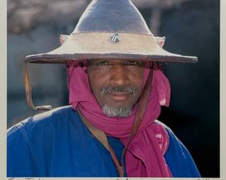 Jim Spillane (American, 1950s-) Photograph - "Mali" | Portrait of a smiling Mali man with a gray beard wearing a textured straw hat and a bright pink head scarf.
Photograph
Framed (gold frame) and matted (white)
Signed by artist (lower right): "Jim Spillane" in pencil
Titled by artist (lower center): "Mali"
Numbered by artist: N/A
Sight: h. 10.5" x w. 11.5"