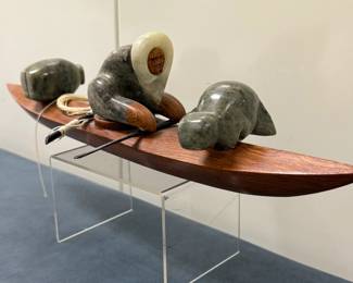 Inuit Figurine (Alaskan) - Kayak | Wooden kayak with three soapstone figurines, an Inuit paddling the kayak and two friendly seals hitching a ride. 
Wood and soapstone carving
Signed by artist (bottom): "Lenwood" [indistinguishable] and "Elim, Alaska"
Titled by artist: N/A
Numbered by artist: N/A, but dated "1994"