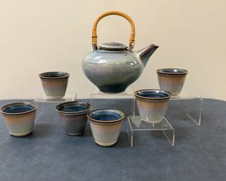 (7pc) Glazed Ceramic Tea Set with Bamboo Handle | Tea set with six modern style ceramic glazed tea cups and a matching tea pot with bamboo handle. 
Tea cups: h. 2.5 in. w. 3 in. 
Tea pot: h. 6.5 in. (lid) x w. 8 in. (spout); h. 9.5 in. (handle)