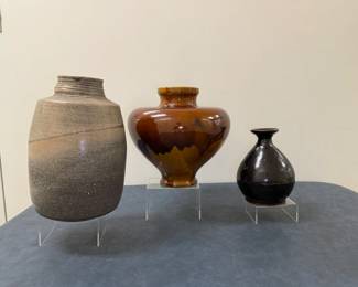 (3pc) Ceramic Pottery - Japanese Vases | Japanese ceramic pottery vases, each with distinct characteristics that define them in shape, texture and form. "Bizen" ware style, in which a unique speckled pattern emerges through the firing process.
Glazed style with rich brown drips over lighter brown tones, popular in the late 19th century. 
"Cizhou" ware style with a deep, dark glaze. This is shaped more like a bottle for sake or wine.