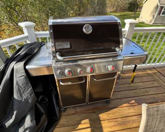 Weber grill in great condition - propane tank attached and cover is on the left