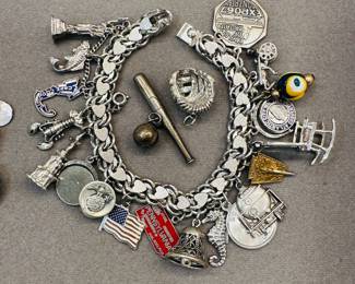 A loaded vintage sterling silver charm bracelet with many sterling silver charms – and a baseball bat, baseball, and catchers mitt silver charms!