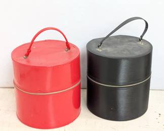 Vintage mid-century hat or wig boxes, one red and one black; zippered, round carrying cases with a handle