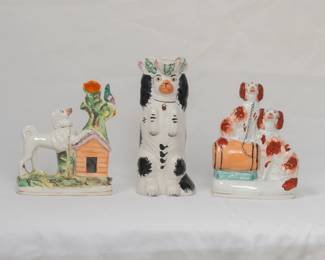 Antique Staffordshire flat back ceramic spill vase modeled as a dog next to his doghouse, looking up at a bird resting on a tree trunk; a 19th century Staffordshire King Charles spaniel jug, the dog sitting up in begging position and wearing a hat in the "Toby Jug" style; and a Staffordshire flatback figurine of two King Charles Spaniels, one perched on a barrel. The flat back figures were usually placed on fireplace mantels.