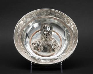 Rare Christofle & Cie 19th C Silver Baby Hercules Bowl – Silver plated copper bowl with high-relief decoration of a bust of the child Hercules grasping snakes. The base inscribed Christofle & Cie, Tresor D'Hildesheim, Fac-simile Galvanique. Circa 1869, and ​​numbered from an edition of 260. 8.5” wide. French silversmith Christofle expertly crafted facsimiles of the Hildesheim Treasure—the largest collection of Roman silver found outside imperial frontiers—unearthed on October 17, 1868 in Hildesheim, Germany. Napoleon III is said to have tried to acquire it, but the entire find, after being cast, was bought by the Berlin Museum on 17 September 1869. The exquisite work of Christofle & Cie mean that the collection of Roman tableware from the Hildesheim Treasure, jealously guarded in the Berlin Museums, could be appreciated in the rest of France and Europe.