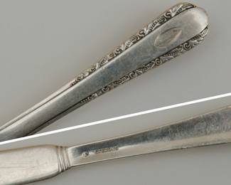 Closeup of piece from the International Silver "Moonglow" pattern sterling silver service for ten with extras. (Knives are sterling handled, butter knives are solid sterling silver.)