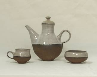 Mid-century Modern pottery: a coffee pot, creamer and sugar bowl from Danish artist Henrik Ditlev Larsen. The upper portion of each piece is glazed, while the lower half is unglazed chamotte clay.