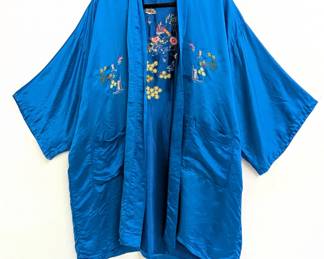 A vintage Chinese blue silk robe, hand-embroidered front and back with multicolor flowers, trees, pagodas and pavilions; Golden Dragon label.