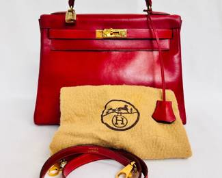 Another view of the beautiful 1993 vintage Hermès Kelly Retourne 32 handbag in rouge box leather, authenticated by Entropy. It comes with a single rolled handle, a removable shoulder strap, and dust bag.