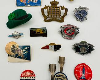 Selection of vintage pins and brooches including a Cincinnati Reds pin, pins for North Carolina and South Dakota, a GoldWater Miller political pin, an enameled hot air ballon postage stamp brooch