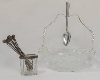 A set of vintage silver cocktail or appetizer picks housed in a silver-rimmed cut-glass stand, and a vintage glass condiment or jam dish with a silver handle for the hanging spoon, frame says Made in Spain. 