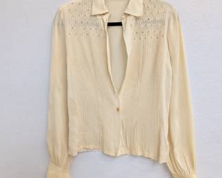 A vintage cream color pleated blouse with smocking and rhinestone accents on the shoulders
