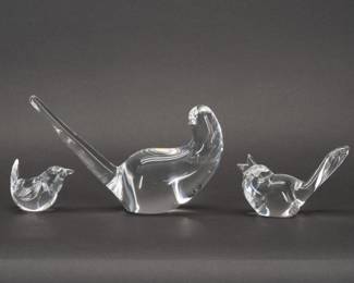 Three Steuben Glass Bird Figurines – A delightfully diverse flock of Steuben glass bird figurines, each with etched Steuben signature: Wren model No. 8603 is a 1990 Lloyd Atkins design, Wild Dove model No. 8426 designed by Bernard X. Wolff in 1973, and Songbird model No. 8112 designed by George Thompson in 1963. Stylish, charming, and whimsical wildlife in sparkling clear hand blown glass to nest in your home and heart.