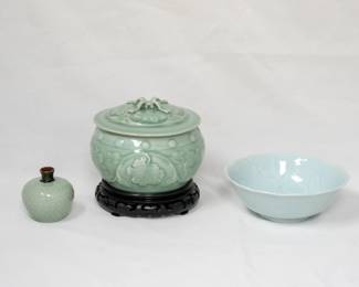 A vintage Chinese celadon glazed porcelain small vase, a vintage Chinese celadon porcelain lidded jar with flowering peony design and on a carved wooden stand, and a vintage Chinese porcelain pale blue glaze bowl with subtle embossed or molded floral pattern