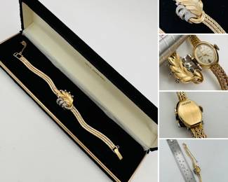 A vintage 14k yellow gold and diamond watch with a leaf-motif cover, a mesh band, and safety chain