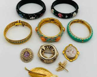A Monet dragonfly brooch, a Stella and Dot turquoise coral rhinestone hinged bangle bracelet, a graceful gold tone leaf brooch, a woven gold tone and blue rhinestone clasp bracelet, a pair of black hand-painted wooden bangles with a floral design, cameo brooch and a gold-tone amethyst brooch