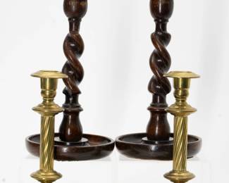 One pair of brass candlesticks, 8.5” high, made by Townshend & Thompson, Birmingham, England circa 1880s–1900 of turned fluted columns above the hunting scene of hounds and stag in repoussé work on the circular bases. The second pair are wood with a round dish base, barley twist columns, the top with brass additions, standing 9” high.