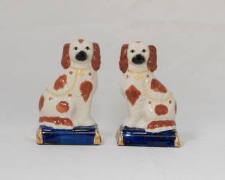 A vintage pair of Fritz and Floyd mirror image dog figurines, King Charles Spaniel dogs seated on cobalt blue gold tasseled cushions