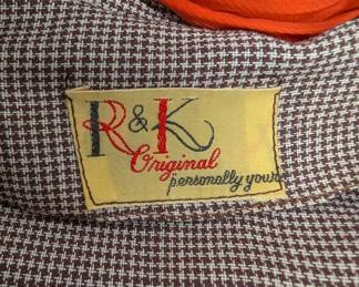 Closeup of vintage R & K Originals black and white plaid jacket with 3/4 length cuffed sleeves, orange necktie and black trim