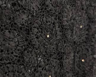 Closeup of the swingy 1960s vintage black raffia crochet sleeveless dress in fit-and-flare style, embellished with rhinestones