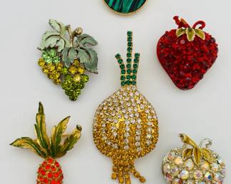 How fun are these vintage costume jewelry brooches?! A Crown Trifari apple brooch, shimmering green in gold tone frame; an enameled and rhinestone strawberry brooch, a strawberry form brooch with Aurora Borealis rhinestones, gold tone metal; a vintage gold tone and enamel carrot brooch with vibrant deep orange rhinestones, a 1950s grape cluster brooch, enameled metal with yellow and green rhinestones; and a vintage "Bermuda onion" pin sparkling with Austrian crystals in clear, citrine, yellow, and green.