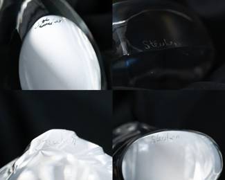 Closeups from the selection of five Steuben Glass figurines rendered in sparkling colorless leaded glass and comprised of: Preening Goose (shape No. 8344) designed by Lloyd Atkins, Heart to Heart hand cooler (shape No. 8626) designed by Eric Hilton, an Eagle (shape 8496) designed by Lloyd Atkins, a Hen hand cooler, and an Elephant Hand Cooler (shape No. 5529) designed by Lloyd Atkins. All engraved with “Steuben' on the base.