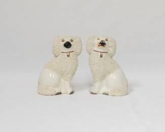 A pair of antique Staffordshire pottery poodles, often referred to as "confetti" or "gravelware" dogs due to their distinctive textured coats. 