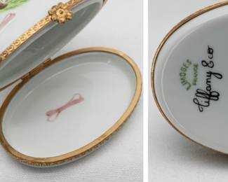 Another view of the hand-painted Limoges porcelain trinket box with a Cavalier King Charles Spaniel reclining on the lid near a pink dog bone, the box and lid with brass band and flower-shaped clasp. Marked to the base with Limoges France and Tiffany & Co, showing this was made in the Limoges region of France and sold by Tiffany & Co.