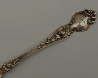 Closeup of a piece from the antique R. Wallace & Sons sterling silver spoons and forks together with a baby spoon, in the "Violet" pattern, circa 1900