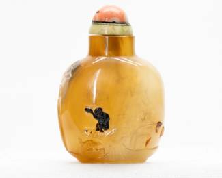 A Chinese Carved Agate Snuff Bottle: Stunning Chinese hard stone snuff bottle of compressed bulbous form with a concave lip and recessed foot, carved to display a pair of ducks swimming amidst lotus plants, with a lone monkey perched on a stylized rock, holding a peach in its upraised paw; jade and coral stopper.