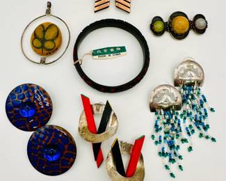 Pair of vintage 1950's Renoir modernist style copper earrings; a 1950s Mexican silver brooch with three differently colored hard stones or glass cabochons; pair of Native American silver and beaded fringe earrings; and a pair of red and black painted wood and silver circle pierced earrings (possibly sterling); pair of round glass disc earrings of vivid cobalt blue and bronze coloring; an art glass and metal wire pendant, signed 76 Carol; and a cinnabar carved lacquer bangle bracelet