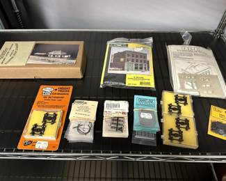 Model railroad supplies in original packaging including GRS ESL-1 kit frosted globe street lamp, Kadee HO Scale 500 Bettendorf Double Truss, Grandt Line HO D&RGW Station Baggage Door 5080, ME Small Spikes 30-106, DPM Carol's Corner Cafe #113 kit and manual