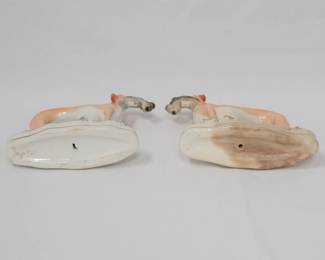Another view of the rare matched pair of mid-Victorian Staffordshire pottery sighthounds (greyhound/whippet), modeled in mirror-image composition; each returning from the hunt with a hand-painted hare, set on a naturalistic base with tree-trunk support