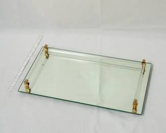 A vintage mirrored vanity tray with lucite rod rails and brass-toned metal corner mounts