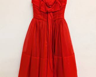 Back view of the vintage 1950s red chiffon cocktail dress with spaghetti straps and a tea-length skirt, the fitted and ruched bodice decorated with rhinestones.