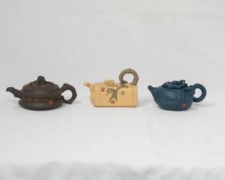 Three Chinese Yixing clay teapots, also known as a zisha teapot, a traditional Chinese style of unglazed stoneware from the city of Yixing