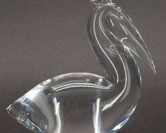 Large signed Steuben crystal glass Pelican sculpture - This Steuben Pelican No. 8222 was designed by Lloyd Atkins and introduced in 1968. A splendid demonstration of the fluidity of glass, the stylized seabird catches light with its crystal clarity. Engraved on the base with the Steuben signature. Measures 6 inches L x 3 inches W x 6 inches H.