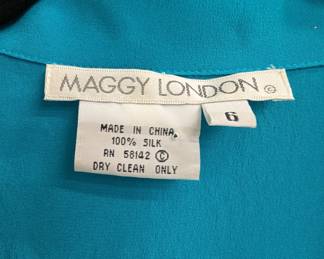 Closeup of Maggy London 100% silk aqua blue button front short sleeve crop top, size 6