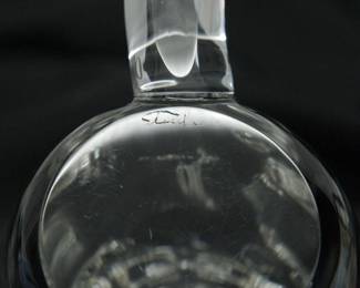 Closeup of Steuben Glass Mink Figurine with Diamond Inset Eyes. This inquisitive clear glass Mink is shape No. 8334 from Steuben’s menagerie of charming animal figures, and has the special touch of inset diamond eyes. Designed by Lloyd Atkins and introduced in 1976. Etched Steuben signature on bottom and stands 7-1/2 inches H. 