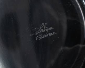 Closeup of the Lalique crystal decanter with a stopper and one tumbler or whisky glass, in the Femmes Antiques pattern originally designed by Marc Lalique in 1952. Clear and satin finish glass, molded with classical figures, and engraved signature Lalique France in script on the base. Decanter 9 1/2 inches tall, tumbler is 4 inches tall.