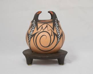 A Native American Zuni Pueblo four-lizard seed pot, beautiful pottery created by artists Avelia and Anderson Peynetsa; signed and dated 2011 on base. This handcrafted pot is made from terracotta clay decorated with mineral pigments and features four lizards wrapped around the body of the pot, with their heads extending above the top.