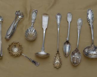 Lovely collection of English and American sterling silver serving pieces including tongs, tea strainers, tea caddy spoon, olive spoon, berry spoon and ladle