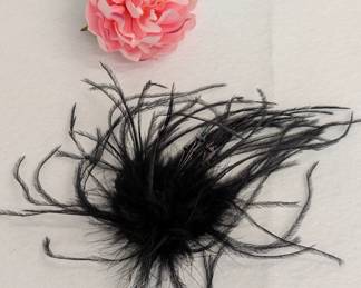 A vintage black ostrich feather fascinator with faceted colored beads, and a fabric camellia blossom