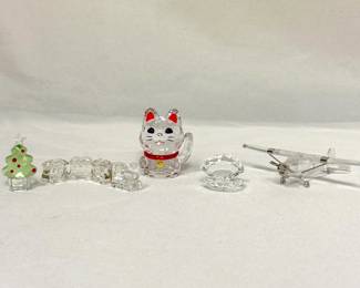 Swarovski Crystal figurines including the Felix The Christmas Tree, Mini Train Set, Asian Symbols Lucky Cat, aka Maneki-Neko; Crystal Shell with Pearl, and Airplane.