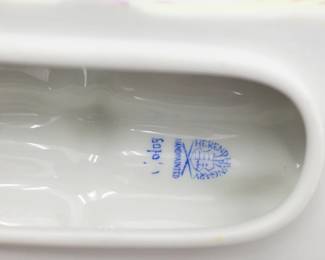 Closeup of interior of the Herend Porcelain hand-painted porcelain trinket box in the form of a bundle of asparagus tied with a pink ribbon. The interior is white glazed porcelain and has a manufacturer's mark on the inside. 5 1/2 inches L x 3 inches W x 3 inches H.