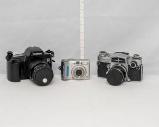 A Canon EOS Rebel S 35mm film camera with a Canon Zoom Lens EF 35-105mm 1:4.5-5.6., a Canon PowerShot A520 digital camera, and a vintage Miranda Sensorex 35mm SLR film camera, produced by the Japanese company Miranda Camera between 1966 and 1972